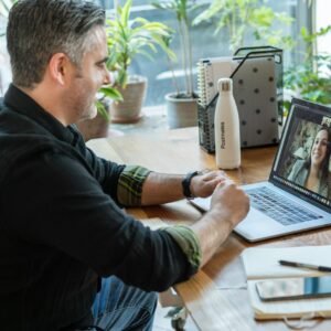 man in black sweater using macbook pro